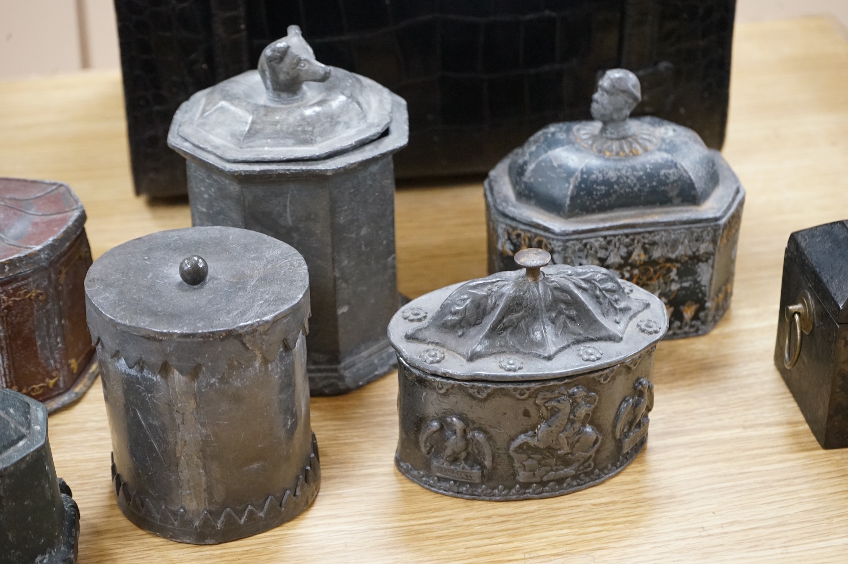 A collection of ten early 19th century lead tobacco boxes, to include an octagonal example, decorated in relief with the remains of red and gilt paint, largest 13cm wide